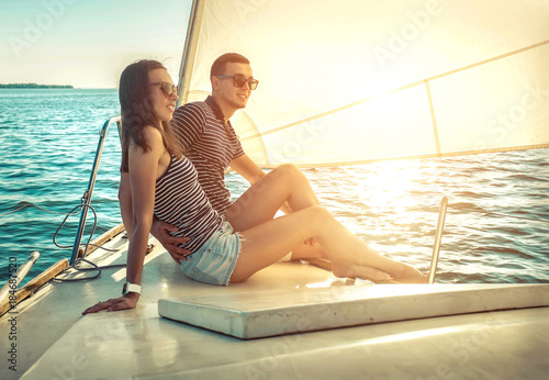 Romantic couple in love on sail boat at sunset under sunlight on © Andrii IURLOV