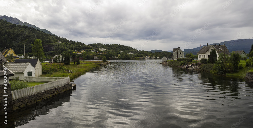 Vistas desde Jondal al lago Hardangerfjorden, con agua, y perspectiva del pueblo. Vacaciones de verano en Noruega, 2017