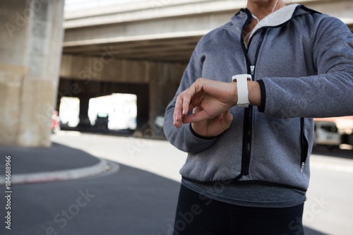 Female jogger using smartwatch on a sunny day