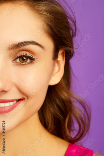 portrait of half face of beautiful woman with beautiful makeup looking at camera