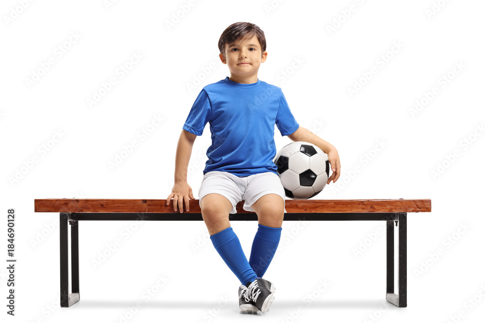 Obraz premium Little footballer sitting on a bench
