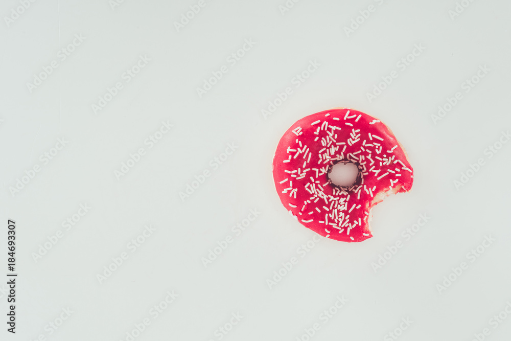 top view of bitten pink glazed doughnut isolated on white top view of bitten pink glazed doughnut isolated on white