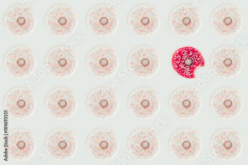 top view of seamless pattern with white and pink doughnuts isolated on white