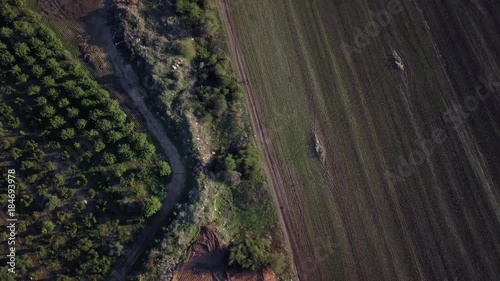 Aerial motion shot of cyclist riding his bicycle along outdoor trail | 4k UHD