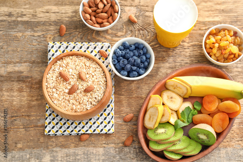 Wallpaper Mural Oatmeal flakes and many different toppings on wooden background Torontodigital.ca