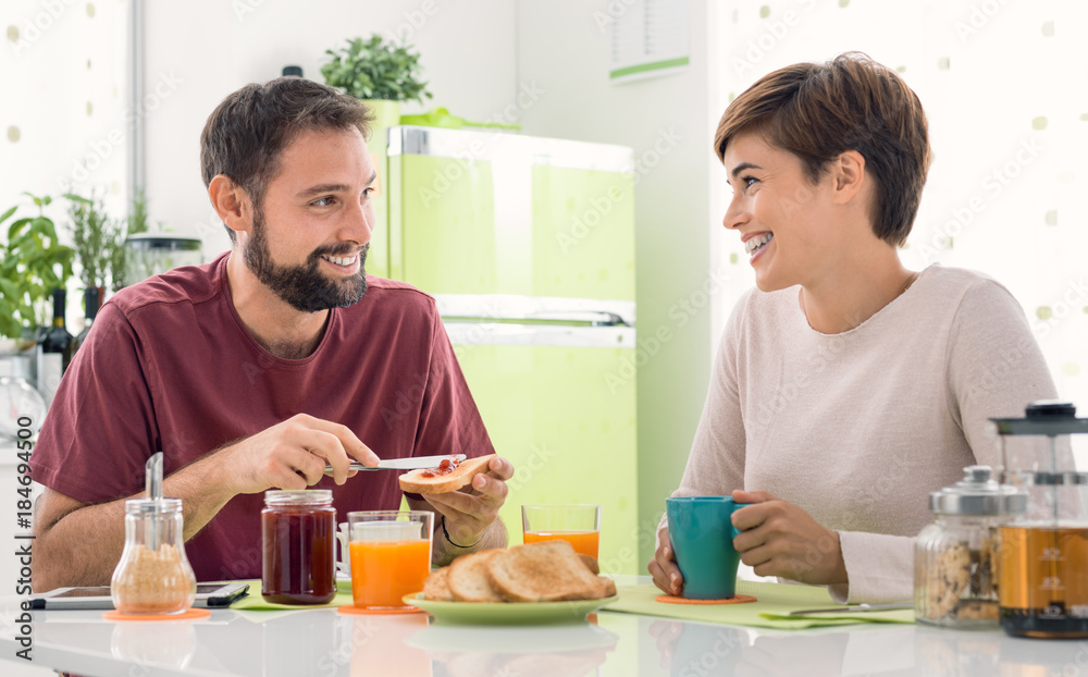 Young loving couple having breakfast at home