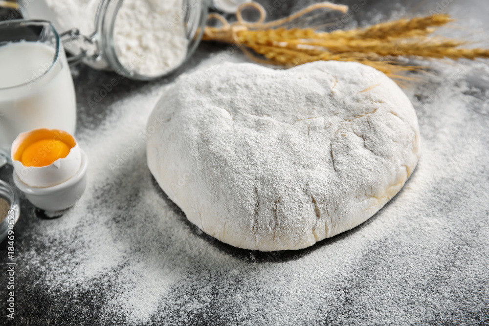 Raw dough sprinkled with flour on table Raw dough sprinkled with flour on table