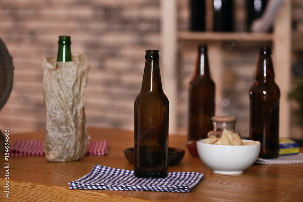 Beer bottles and snacks on table in sport bar Beer bottles and snacks on table in sport bar