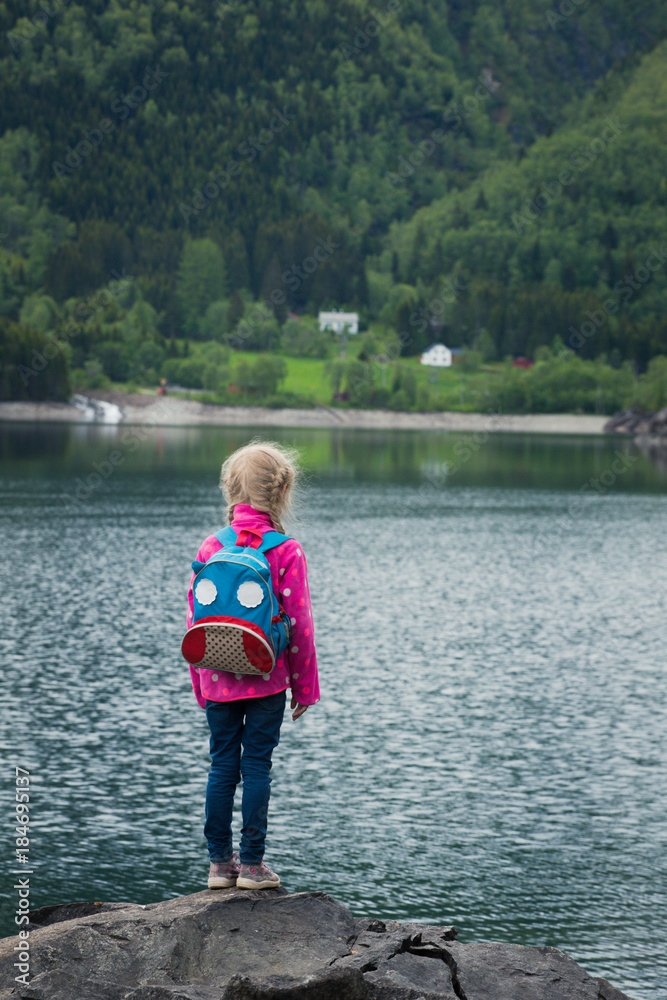 little blonde girl at the shore of norwegian lake little blonde girl at the shore of norwegian lake