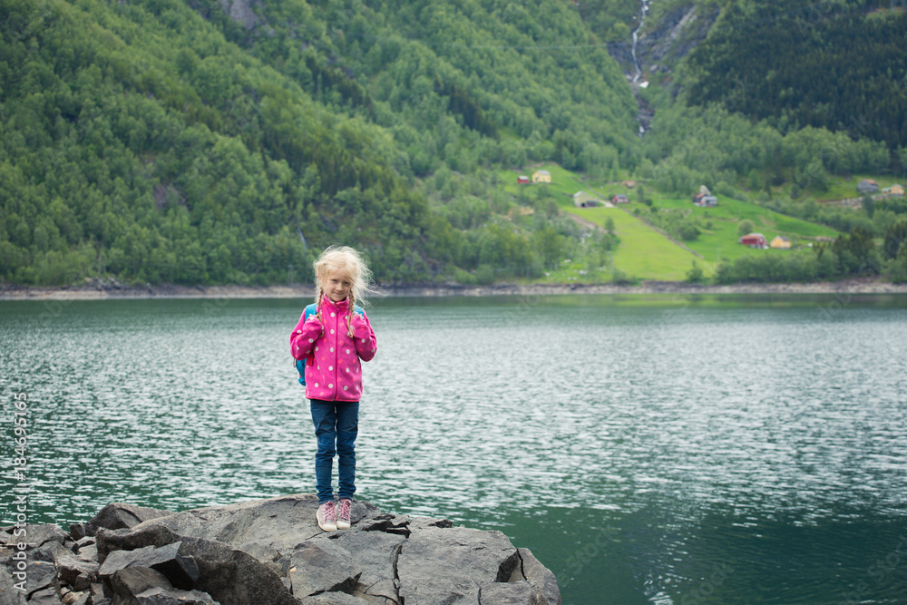little blonde girl at the shore of norwegian lake little blonde girl at the shore of norwegian lake