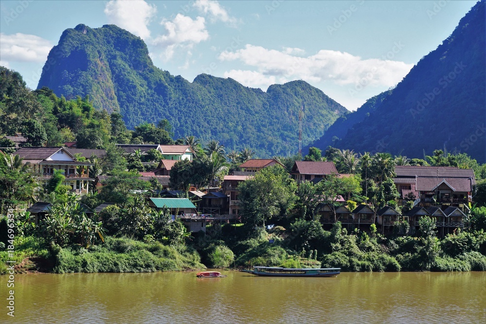 Little town in jungle in Laos on a river with houses
