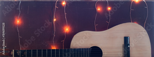 Old guitar on the background of Christmas light,