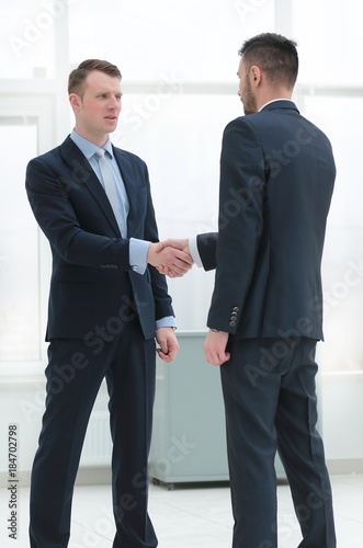 handshake financial partners in the corridor of the office