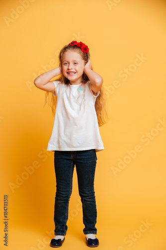 Girl child standing isolated over yellow