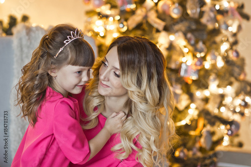 Close-up portrait of a beautiful mom with her daughter on the Christmas