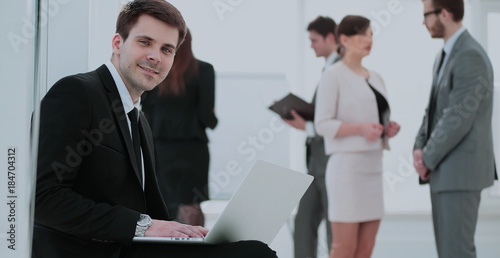 Принти на полотні concept of the Internet: young smiling businessman with laptop s