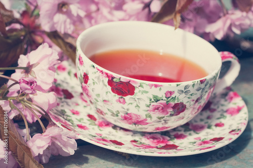 Beautiful cup of English tea with blooming Japanes cherry tree flowers