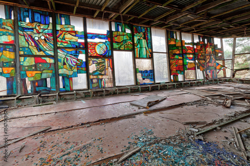 Stained glass inside of abandoned and ruined building of river port in overgrown ghost city Pripyat.