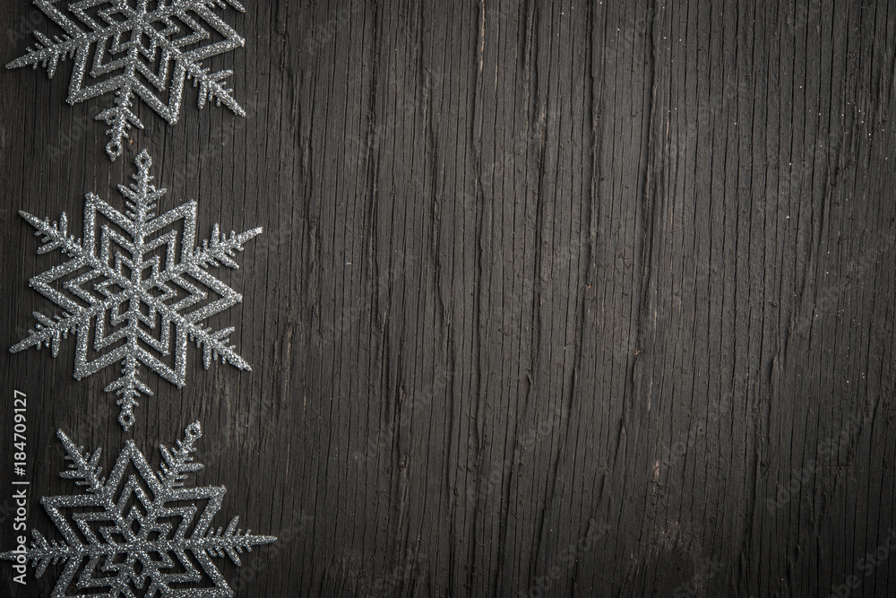 Snowflakes ornament over black rustic wooden background Snowflakes ornament over black rustic wooden background