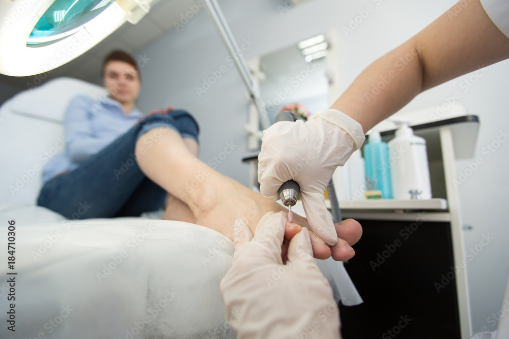 Professional pedicure master making pedicure in salon