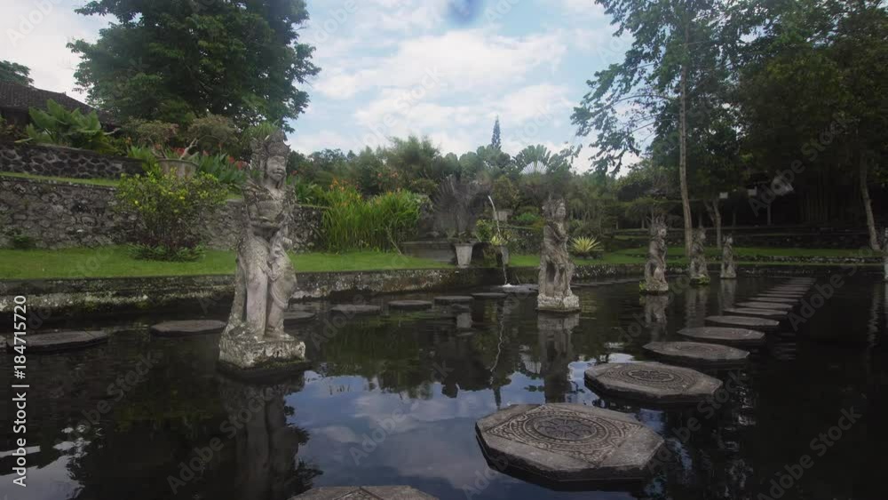 Hindu Balinese Water Palace Tirta Gangga with statues of the gods, fountains on Bali island, Indonesia. Tirta Gangga the former royal water palace is a maze of pools and fountains surrounded by a lush Hindu Balinese Water Palace Tirta Gangga with statues of the gods, fountains on Bali island, Indonesia. Tirta Gangga the former royal water palace is a maze of pools and fountains surrounded by a lush