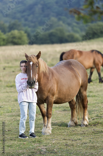 Teenager with Horses in a meadow