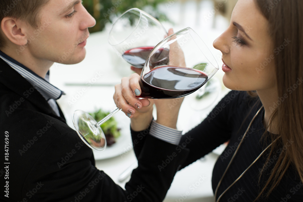 Young happy amorous couple celebrating with red wine at restaurant. Brotherhood Young happy amorous couple celebrating with red wine at restaurant. Brotherhood