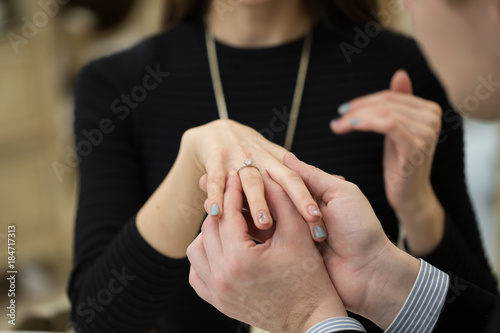 Close Up Of Male Hand Inserting An Engagement Ring Into A Finger