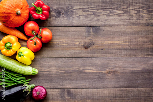 Base of healthy diet. Vegetables pumpkin, paprika, tomatoes, carrot, zucchini, eggplant on dark wooden background top view copyspace