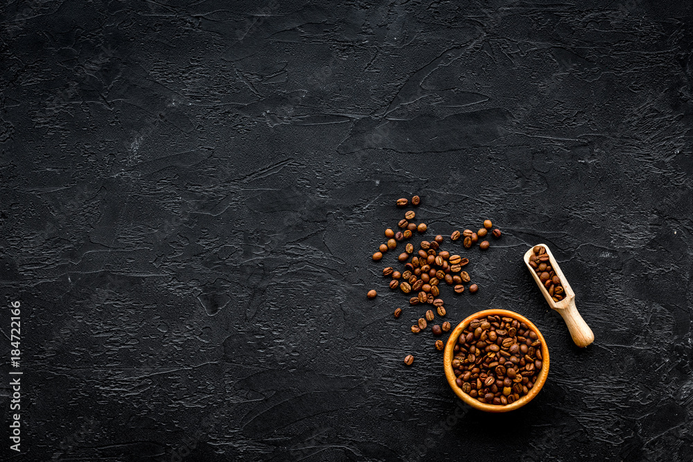 Coffee background. Roasted beans in bowl and scoop on black table top view