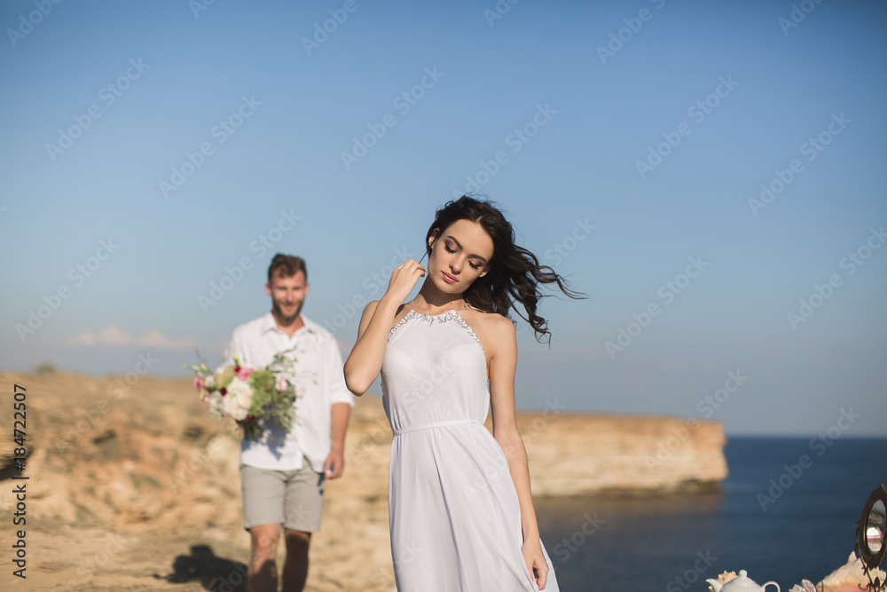 Beautiful young couple on a date. The guy brings flowers.