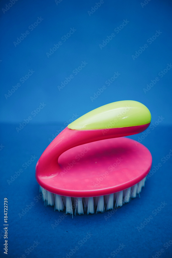 Oval pink clothes brush on blue background Oval pink clothes brush on blue background