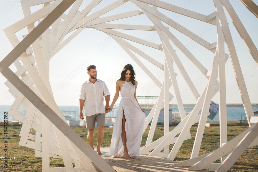 Man and woman posing. Geometric wooden structures. The bride and groom. Man and woman posing. Geometric wooden structures. The bride and groom.