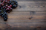 Ripe red and black grape on wooden background top view copyspace
