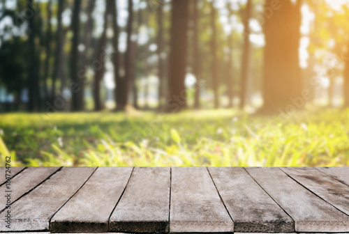 Selected focus empty wooden table and view of green forest blur background with bokeh image. for your photomontage or product display