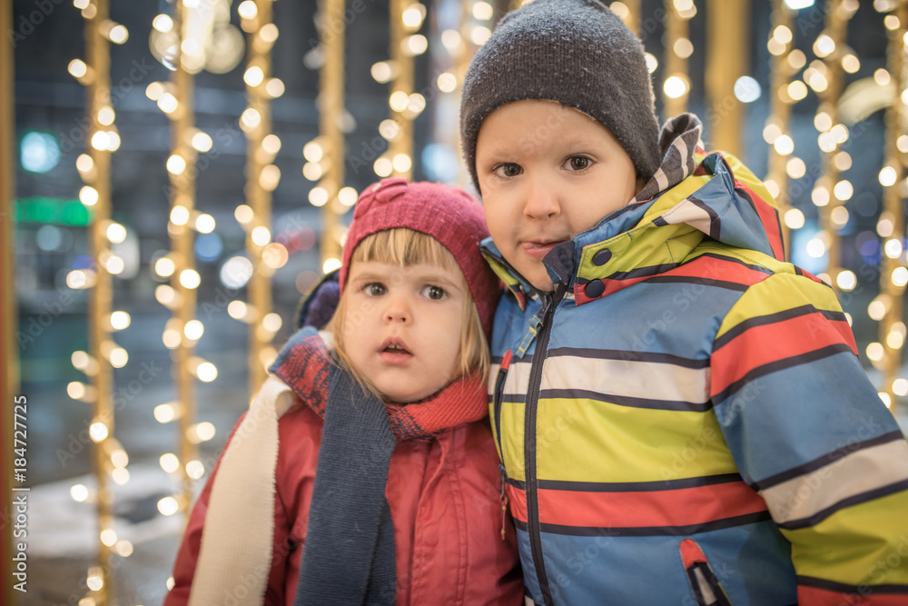 Brother and sister in Christmas night over holiday lihgts Brother and sister in Christmas night over holiday lihgts