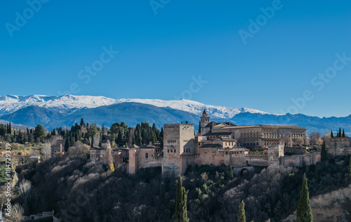 a view of Alhambra in Granada, Spain with Sierra nevada in the background covered in snow