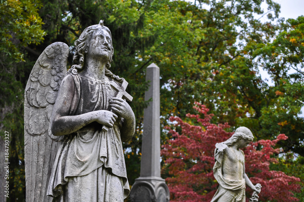 Angel Statue in a Graveyard with Colorful Trees