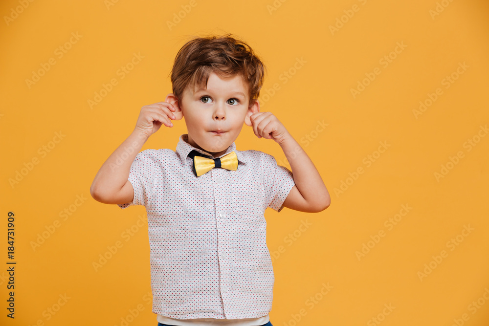 Funny little boy child standing isolated over yellow Funny little boy child standing isolated over yellow