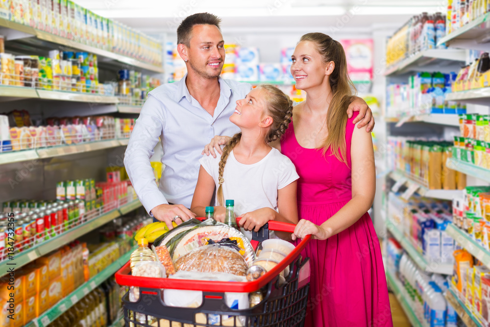 Attractive woman and man with teenager girl in the shop