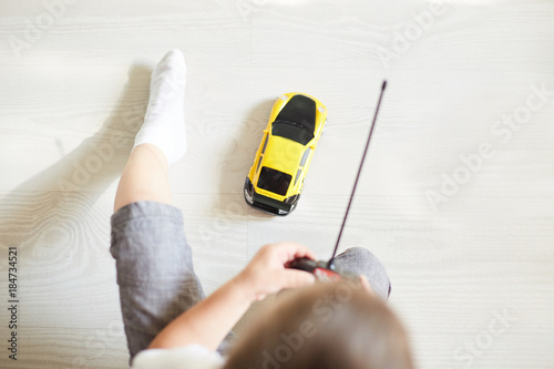 a boy playing with a car remote