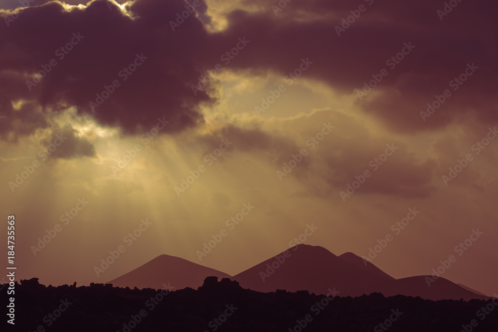 Romantic sunset at rock area. Volcanic area in Lanzarote national park. Mountain silhouette Romantic sunset at rock area. Volcanic area in Lanzarote national park. Mountain silhouette