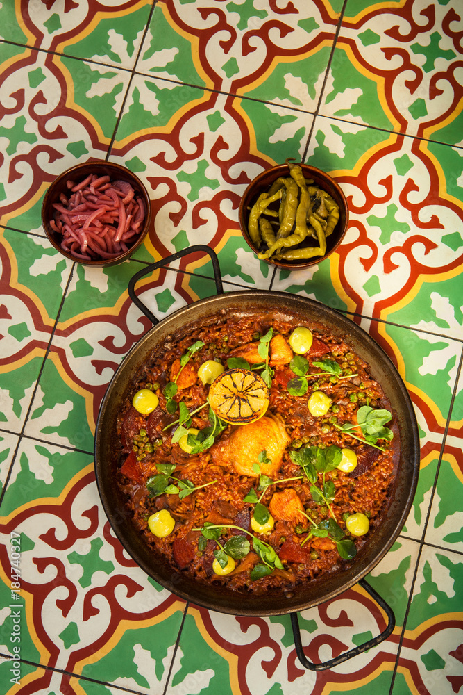 chorizo and pollo paella on tile tabletop chorizo and pollo paella on tile tabletop