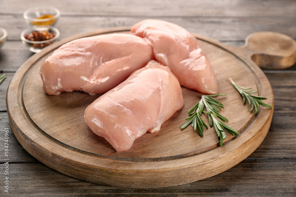 Board with raw chicken fillet on wooden background Board with raw chicken fillet on wooden background