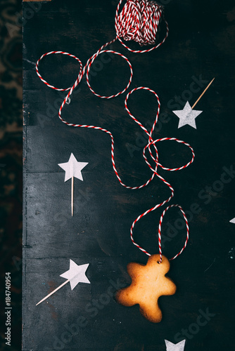 Christmas cookies with the shape of young boy are displayed over a black board with a ribbbon and christmas decoration photo