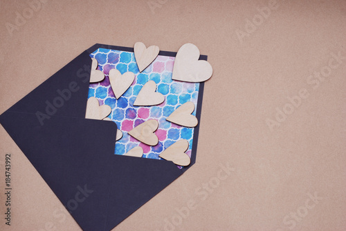 Valentine day Love Blue Envelope with Wooden Laser Cut Heart, with Copy Space. Craft Paper Neutral background photo