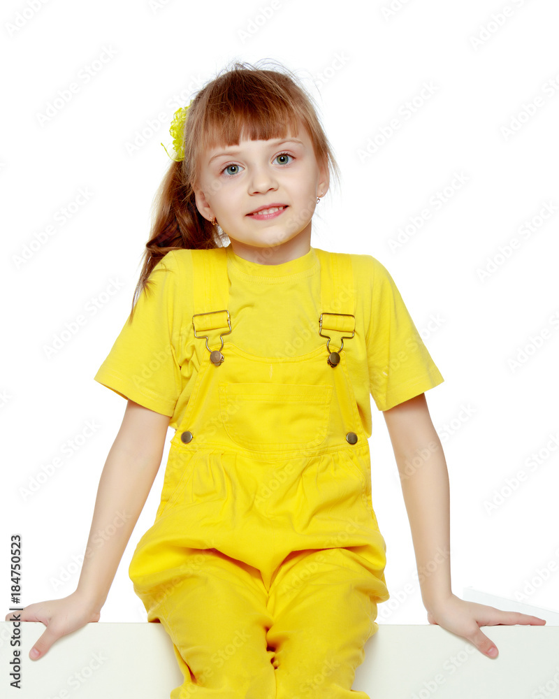 Girl with a short bangs on her head and bright yellow overalls. Girl with a short bangs on her head and bright yellow overalls.