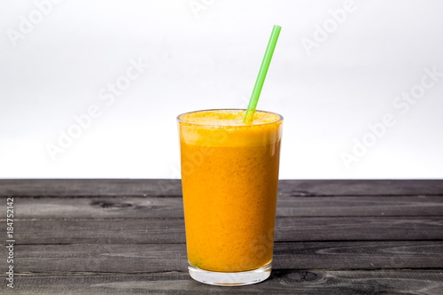 Fresh juice with orange and mandarin. A glass of juice with a straw on a white background.