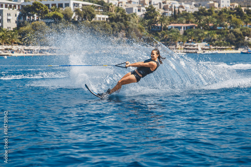 Canvas-taulu Water skis glides on the waves, female athlete on Aegean Sea,