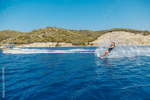 Water skis glides on the waves, female athlete on Aegean Sea,